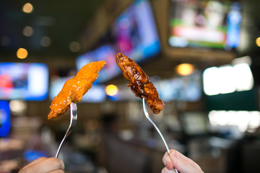 Juicy chicken tenders smothered in spicy sauces on plates